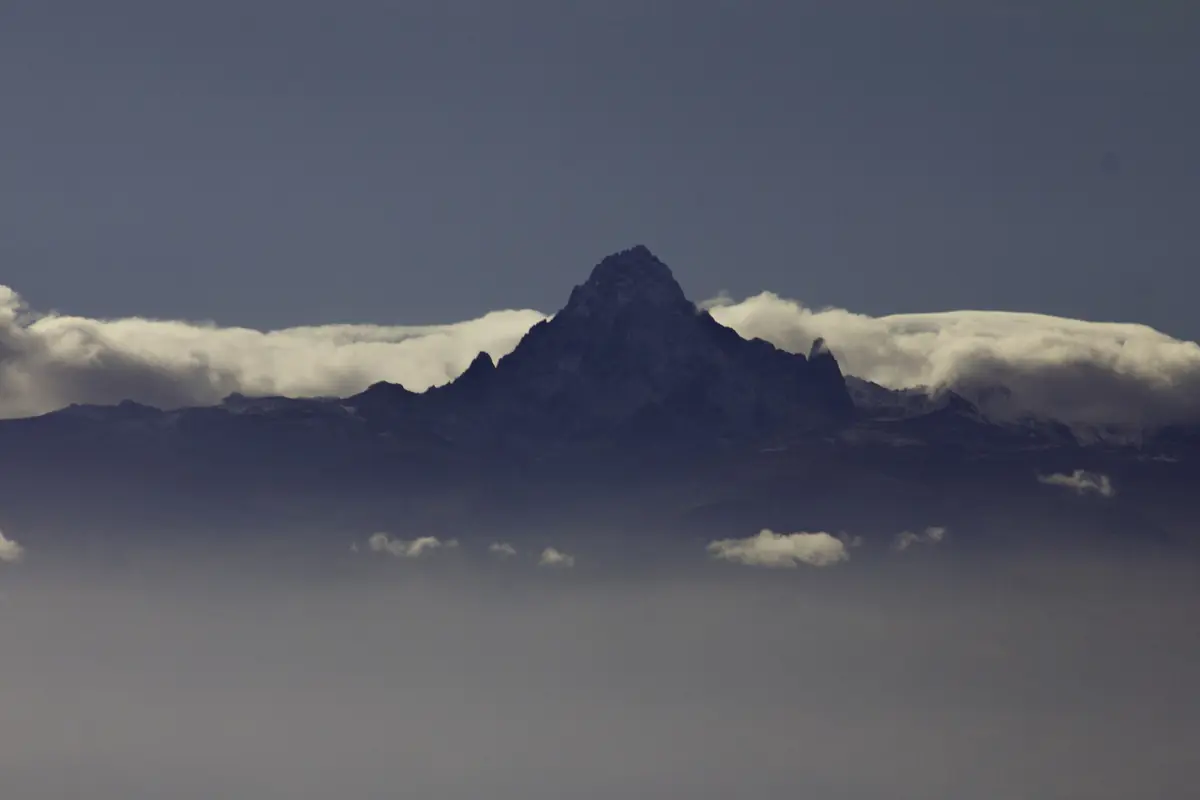 Top van Mount Kenya rijst bij schemering boven een wolkenband uit